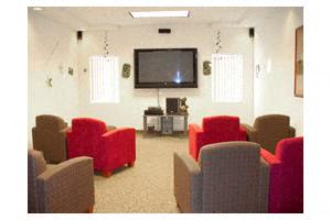 a living room with red chairs and a television